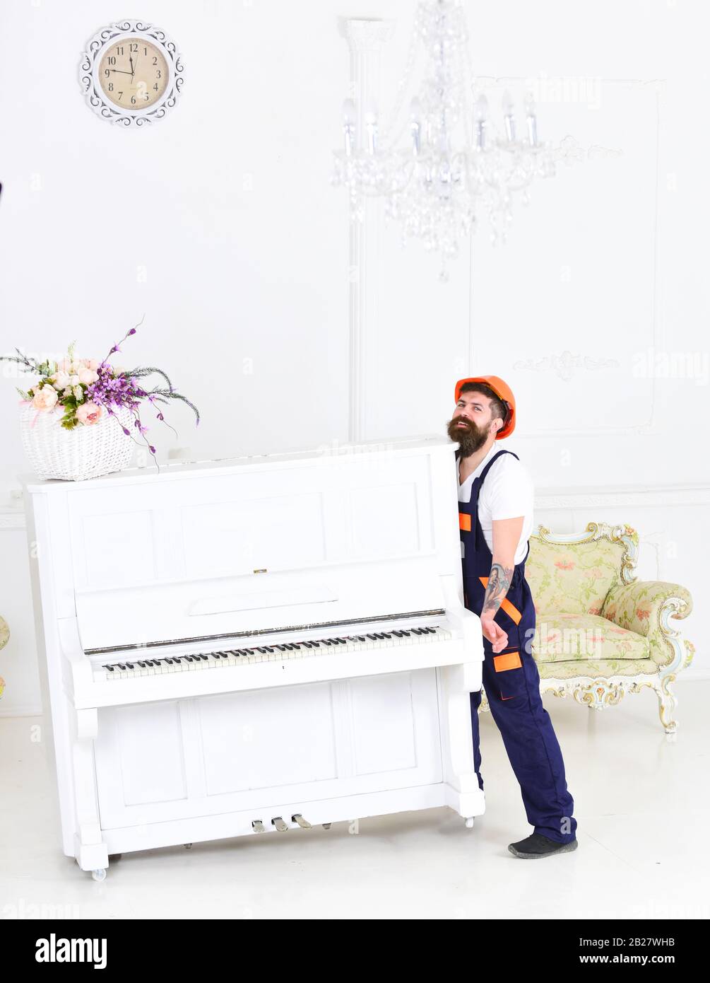 Portrait of smiling worker lifting white piano with flower vase in room  with antique furniture. Strong bearded man moving heavy pianoforte isolated  on white background Stock Photo - Alamy