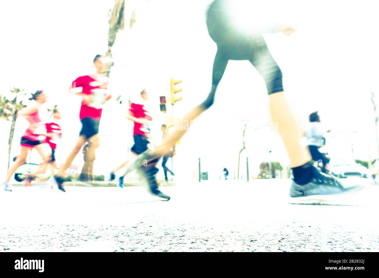 Blurred image of people running in massive marathon on a sunny summer day. Healthy living, workout and sports concept. Stock Photo