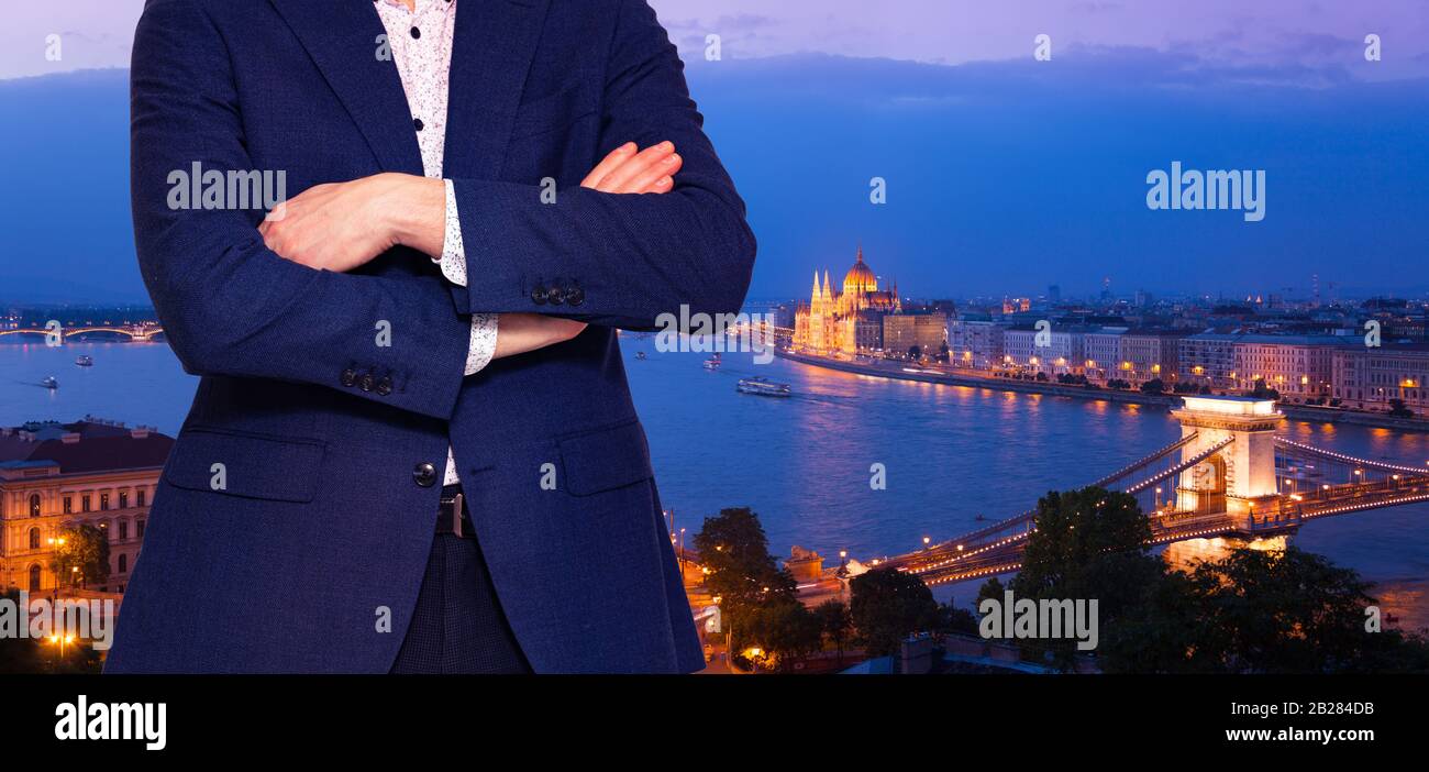 Businessman in suit standing near the window with hands folded in Budapest downtown, Hungary Stock Photo
