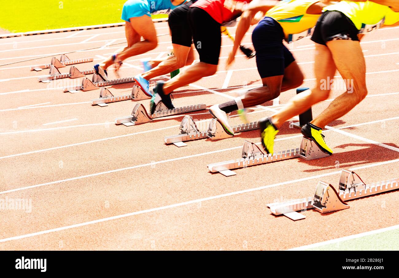 Close-up of group of sport men starting running sprint view from back Stock Photo