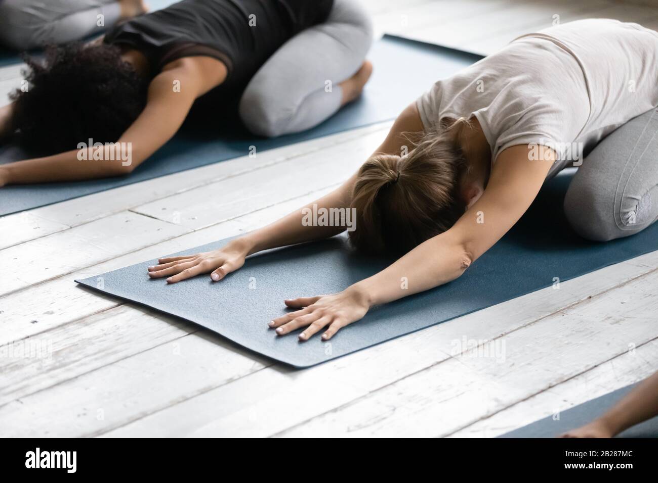 Women practicing Child Pose reducing fatigue after workout close up Stock Photo