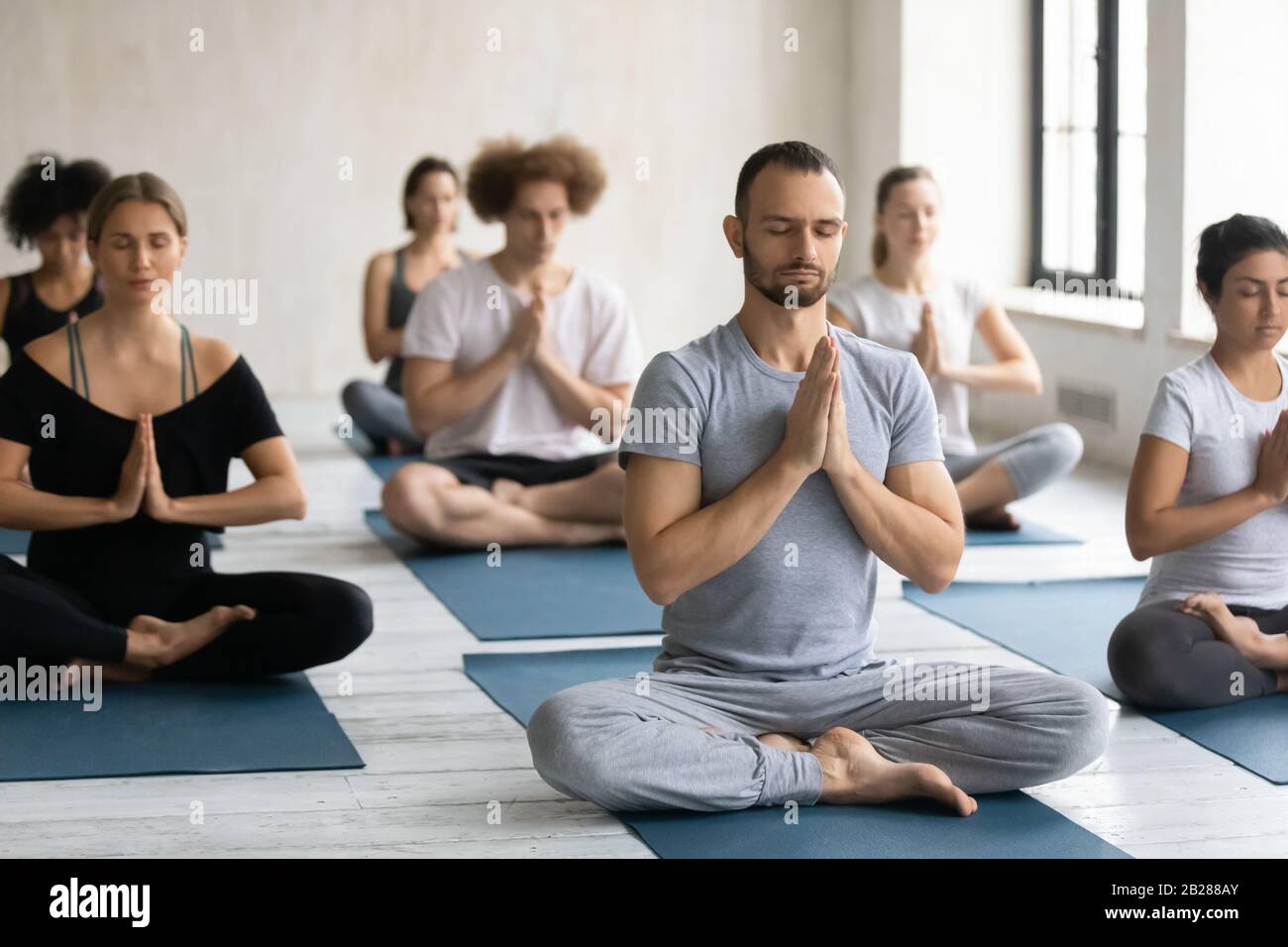 Meditation enlightenment practice with teacher during yoga class Stock Photo