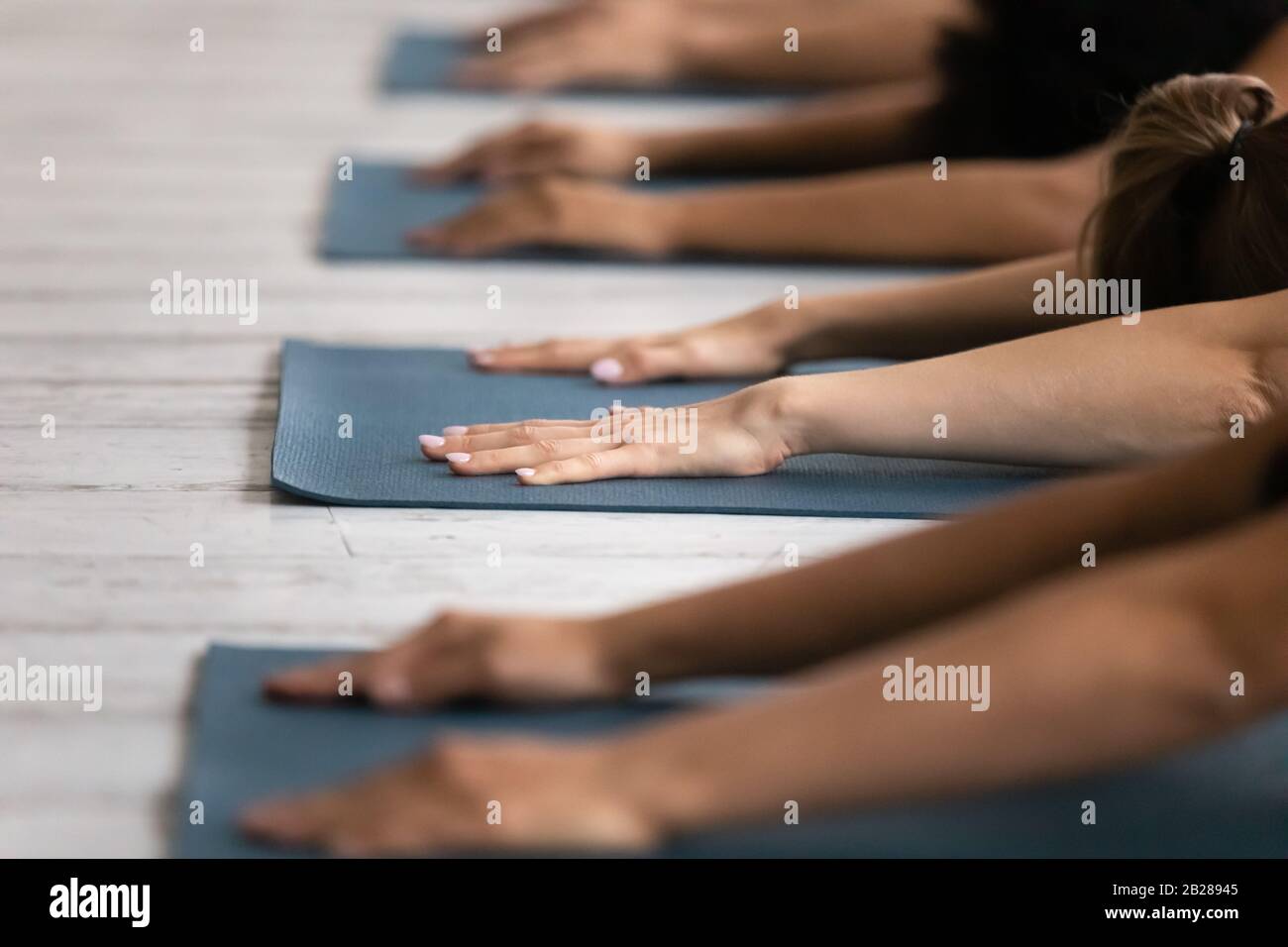 During yoga session people lying on mats performing Child Asana Stock Photo