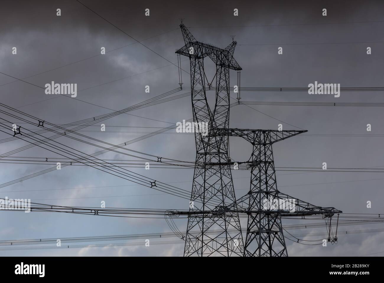 High voltage pylons on dry grassland Stock Photo