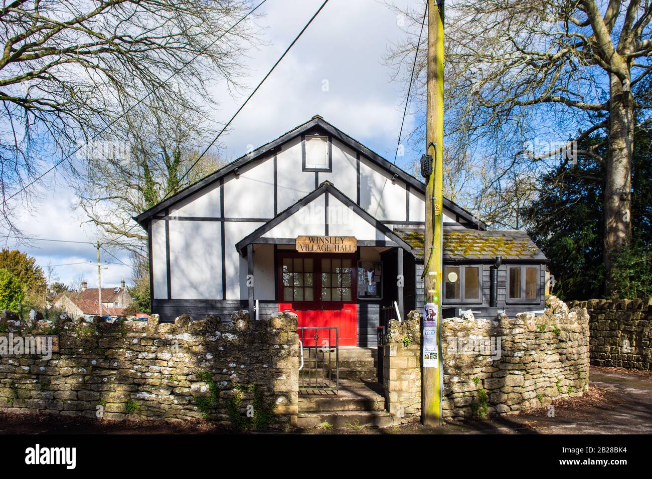 The Winsley village hall with a carved wooden sign over red doors in