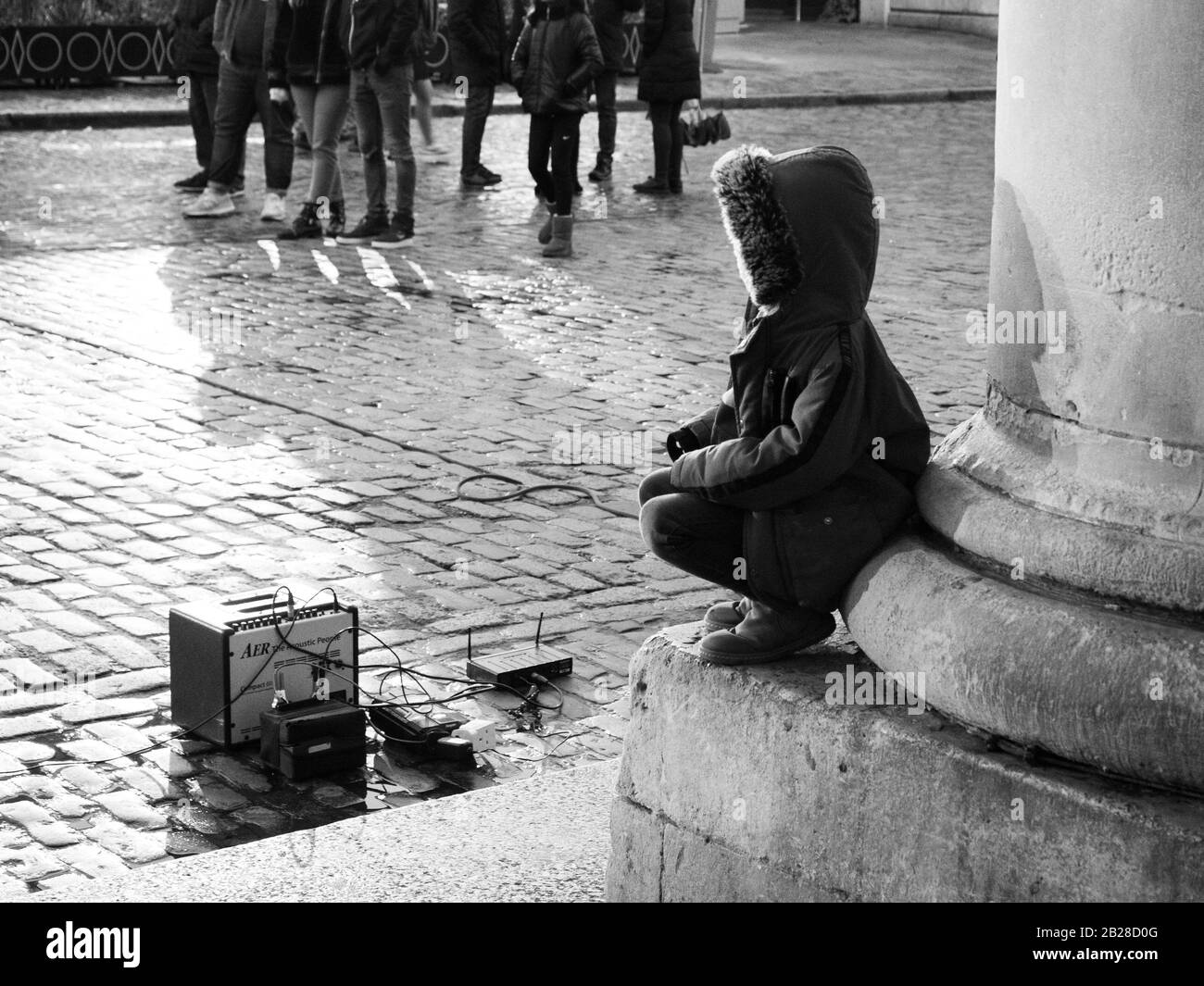 Child sits alone in Covent Garden in London Stock Photo