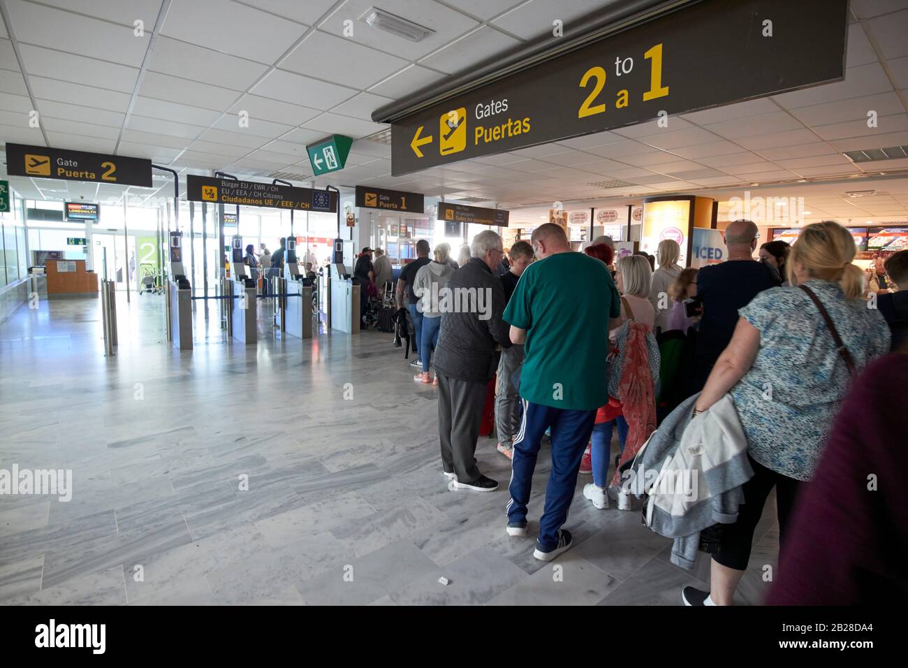 british and irish passengers queue at gate for flight home after winter sun break half term terminal t1 arricife cesar manrique-Lanzarote airport Stock Photo