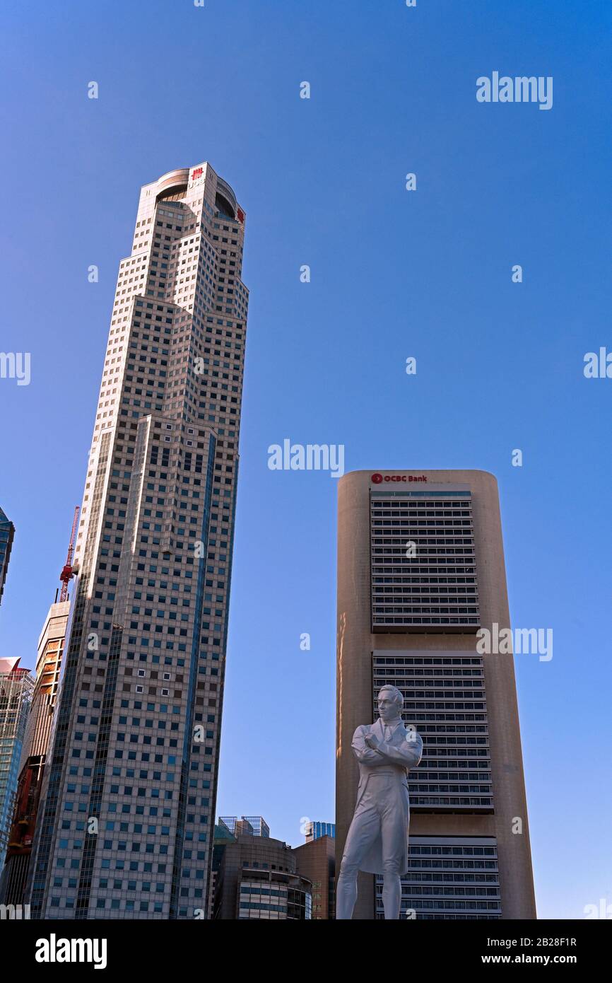 singapore, singapore - 2020.01.24: thomas stamford raffles statue at raffles landing place and high rise office buildings of uob and ocbc in central b Stock Photo