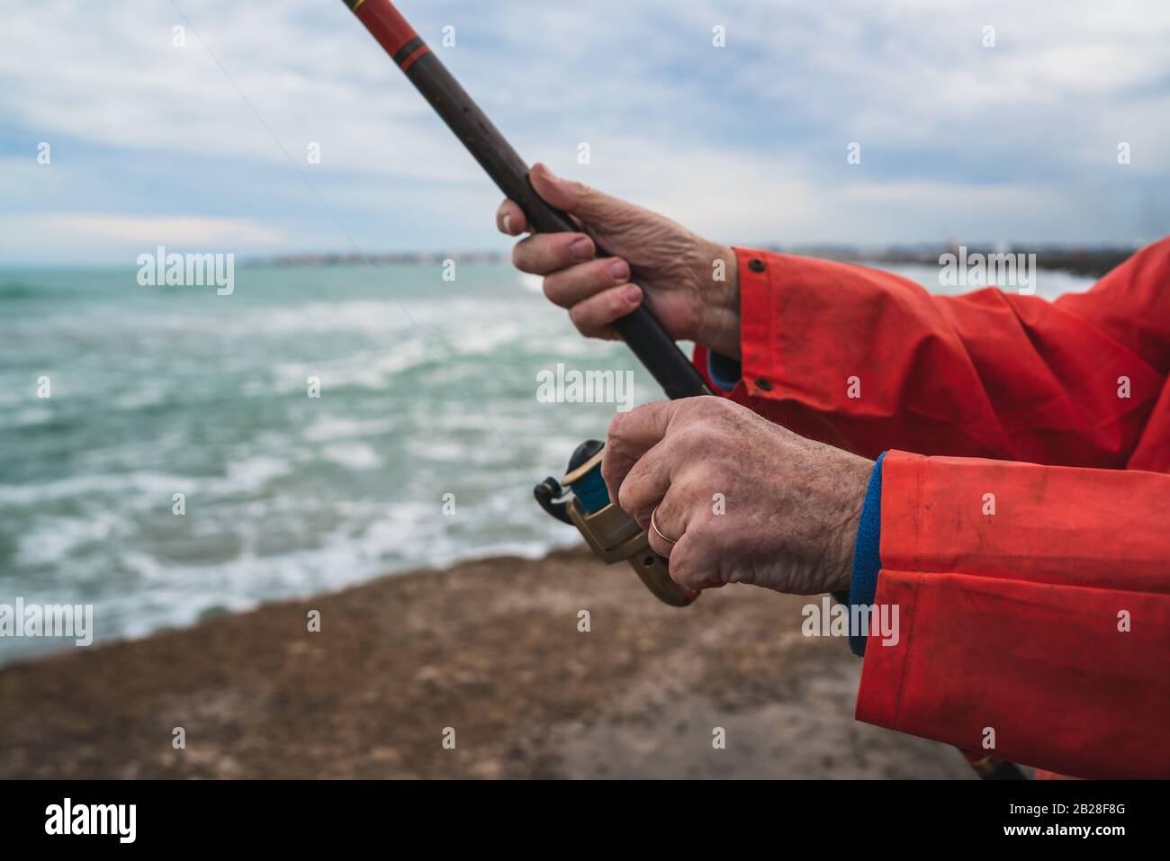 Close-up of a fisherman holding a fishing pole. Fishing and sport concept. Stock Photo