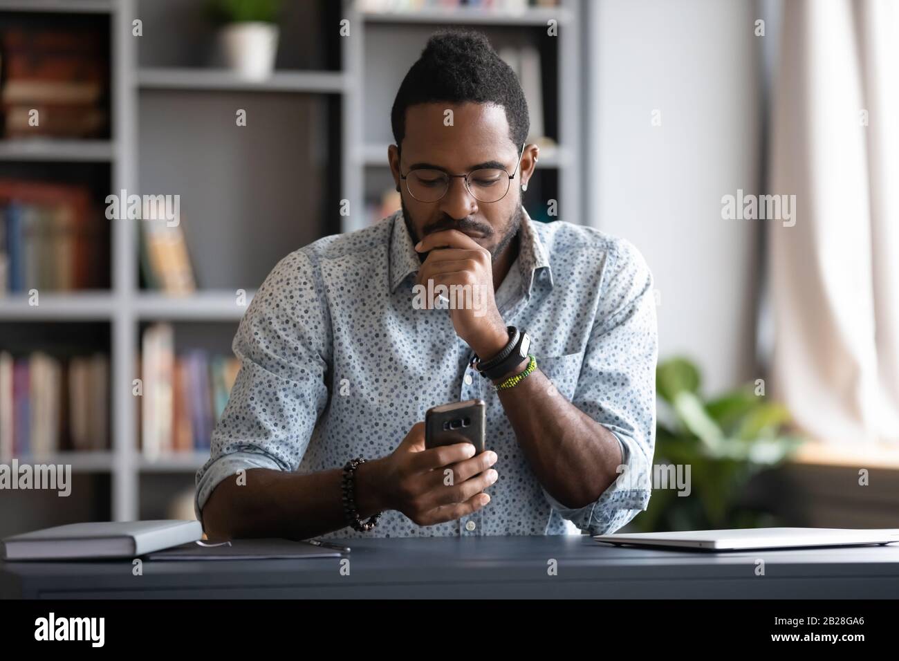 Focused millennial businessman checking email in mobile application. Stock Photo