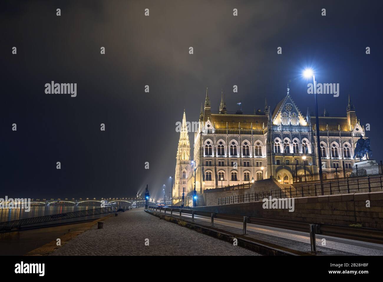 View Of Illuminated Hungarian Parliament building from alley over Danube river during the night. Stock Photo