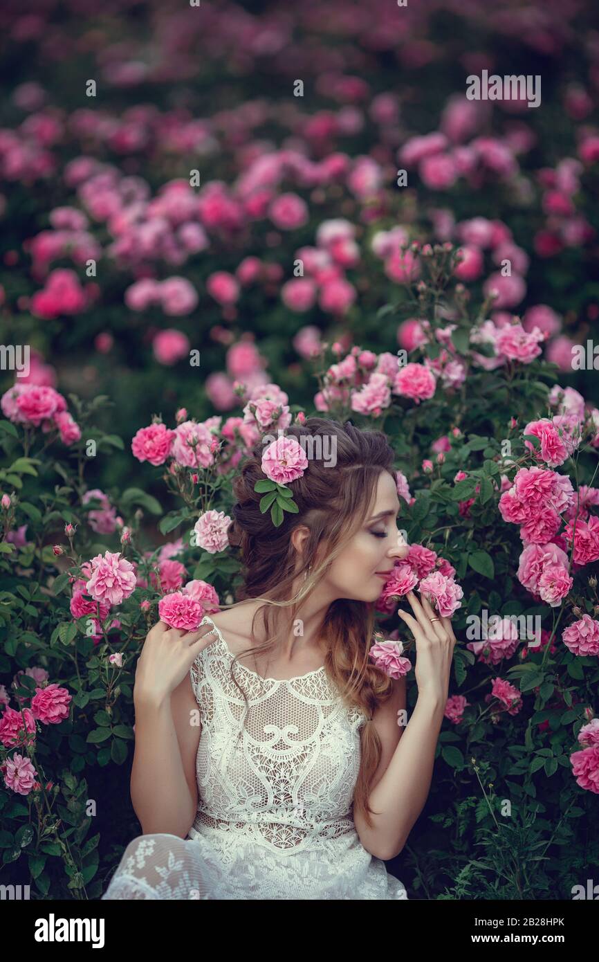 Download Beautiful Woman In A Floral Park Garden Roses Makeup Hair A Wreath Of Roses Long Wedding Dress Woman In Boho Style Stock Photo Alamy