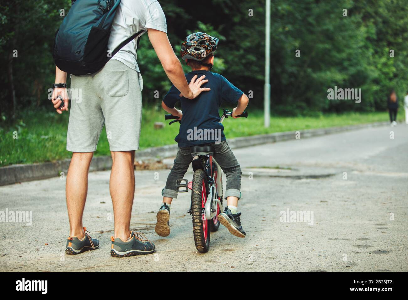 father teaching son how to ride bicycle Stock Photo