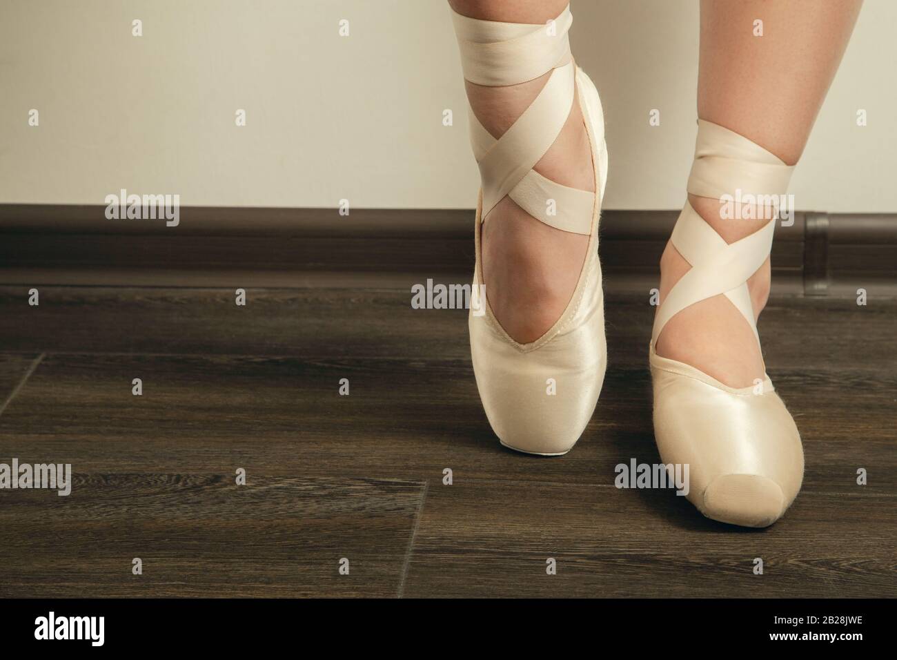 female ballerina feet in pointes on a wooden floor closeup image Stock Photo