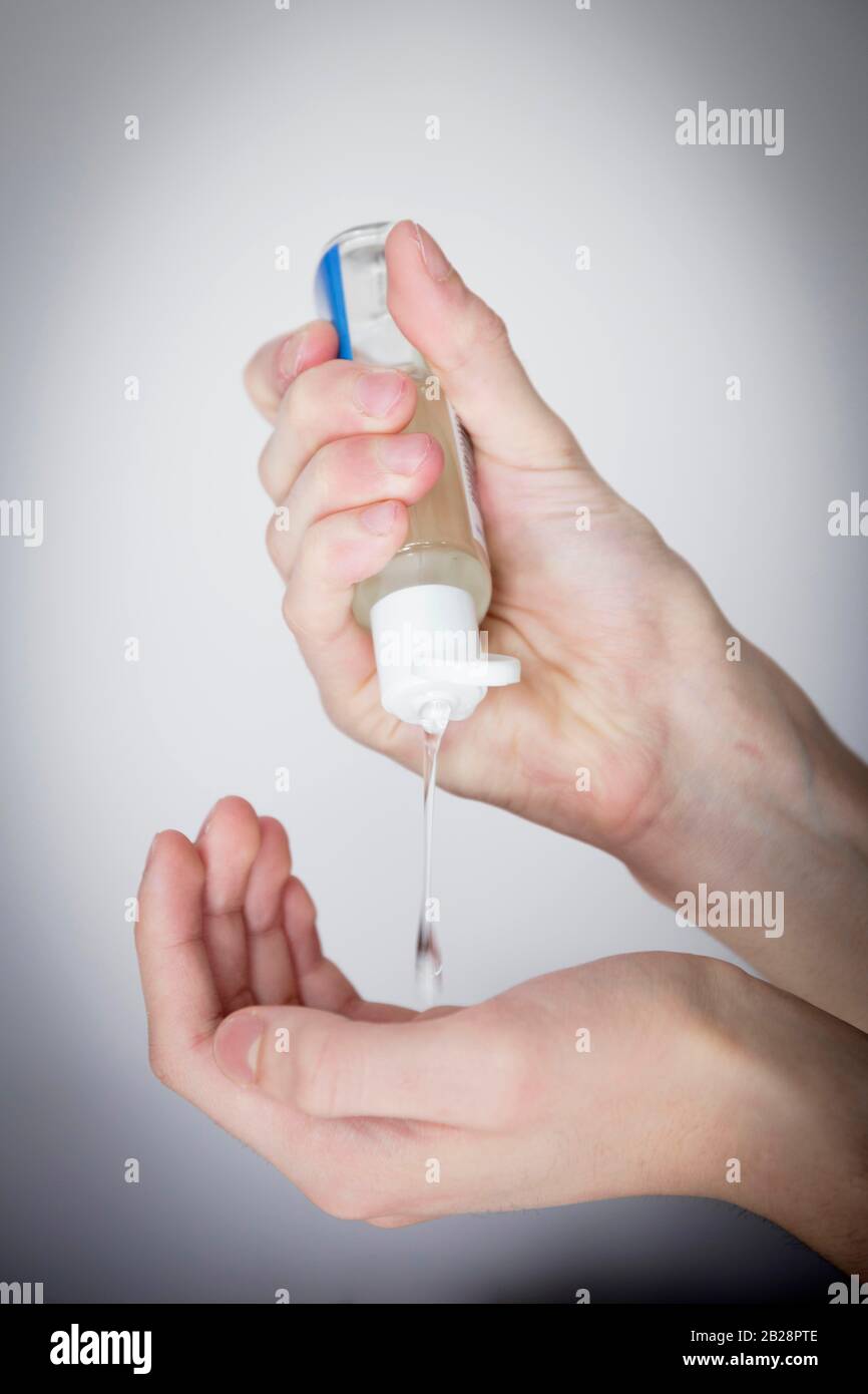 Disinfecting hands with alcohol gel Stock Photo - Alamy