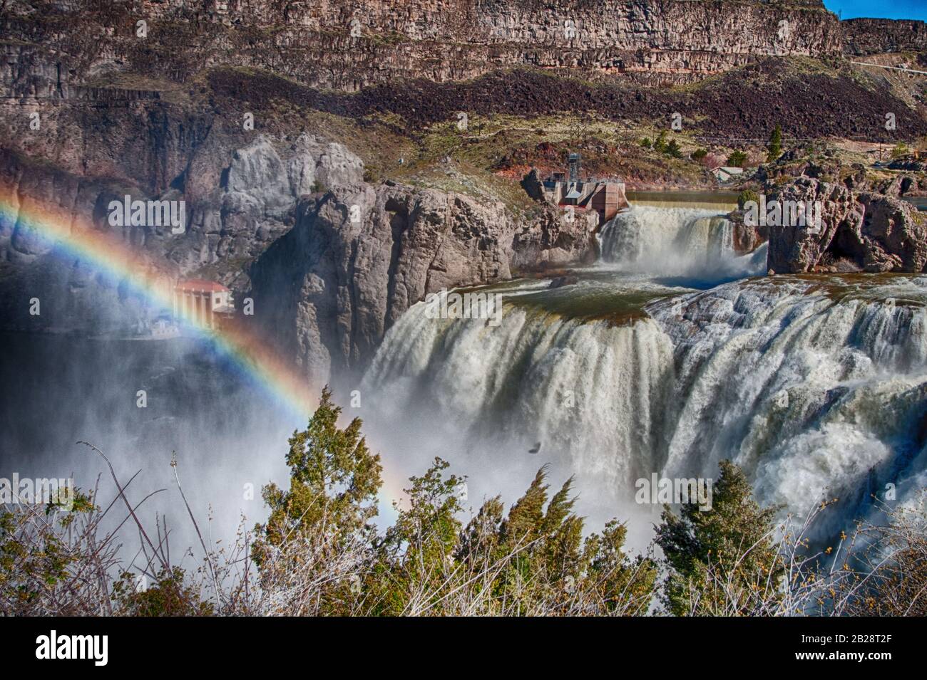 Midmorning Rainbow from the mist of the Niagara of the West, Shoshone Falls in Southcentral Idaho with its colorful Earth tone shores and rock formati Stock Photo