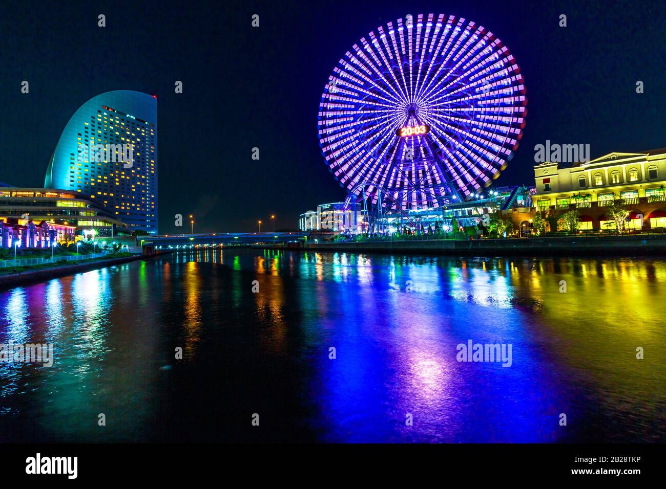 Yokohama Cityscape in Japan of Minato Mirai District at night. Colorful ferris wheel reflected in the bay water. Stock Photo