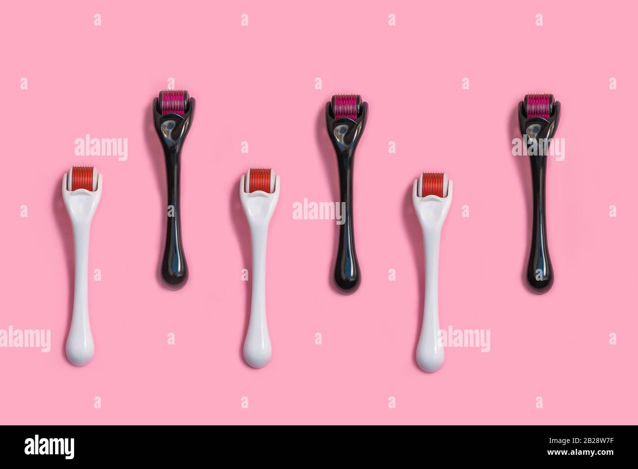 Micro needle derma roller for home face care on light pink background. Top view, flat lay, pattern Stock Photo