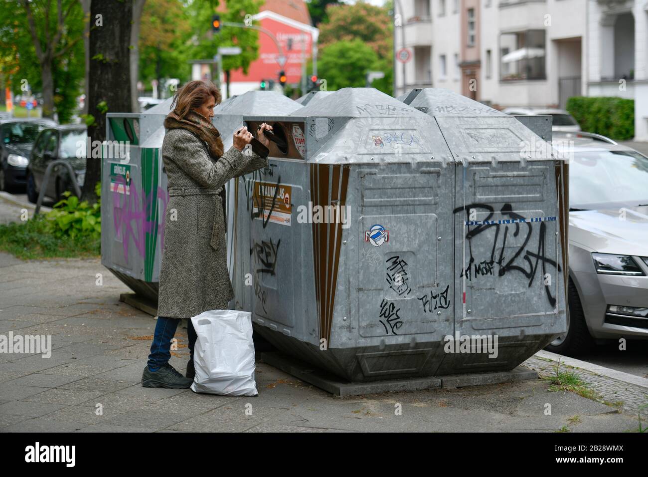 Gestelltes Foto, Seniorin, Altglascontainer, Glasrecycling Stock Photo