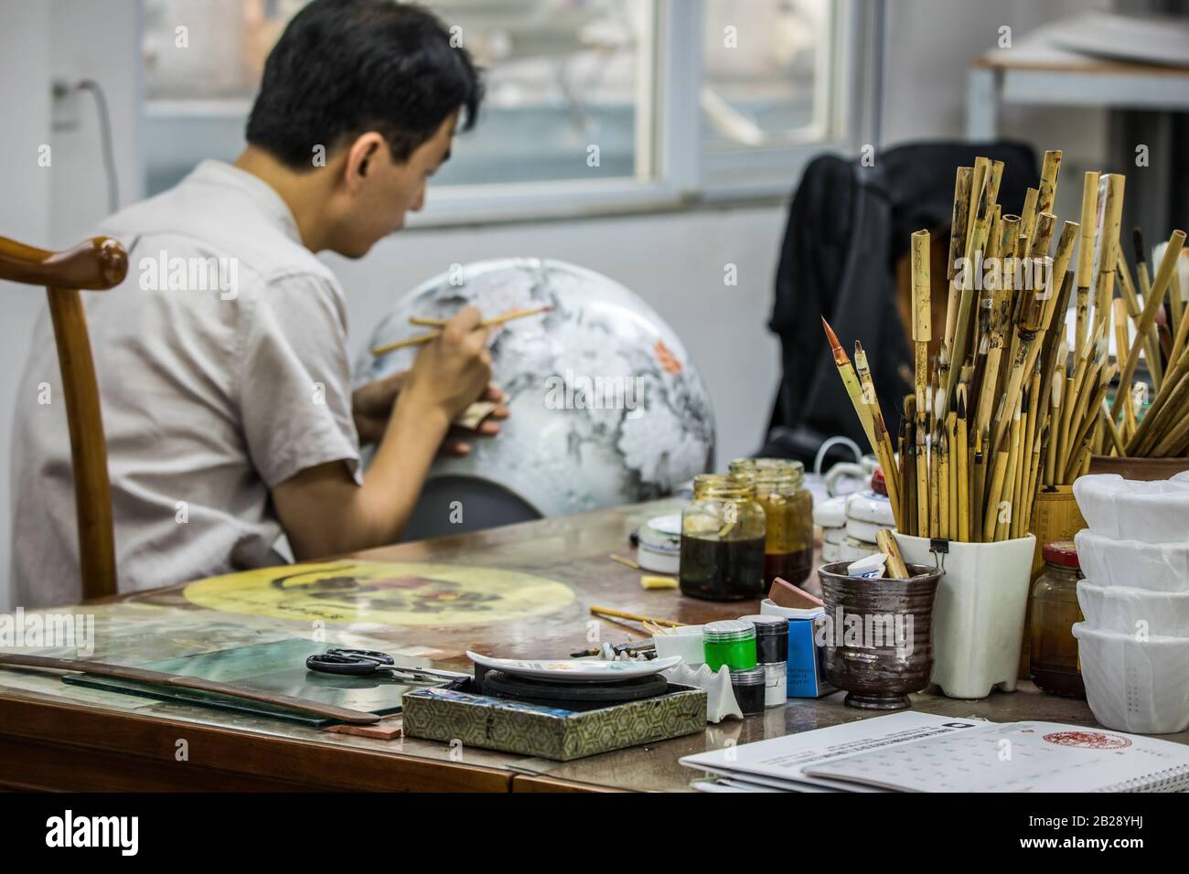 BEIJING, СHINA JUNE 03 Chinese craftsman paints a large porcelain