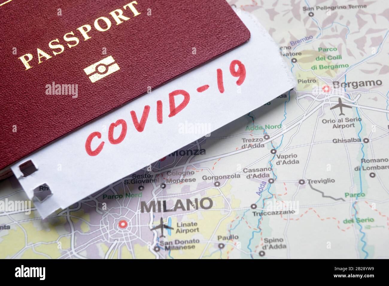 Coronavirus epidemic and travel restrictions in Italy concept. The note COVID-19 and passport on map with Milan. Novel corona virus outbreak. Border c Stock Photo