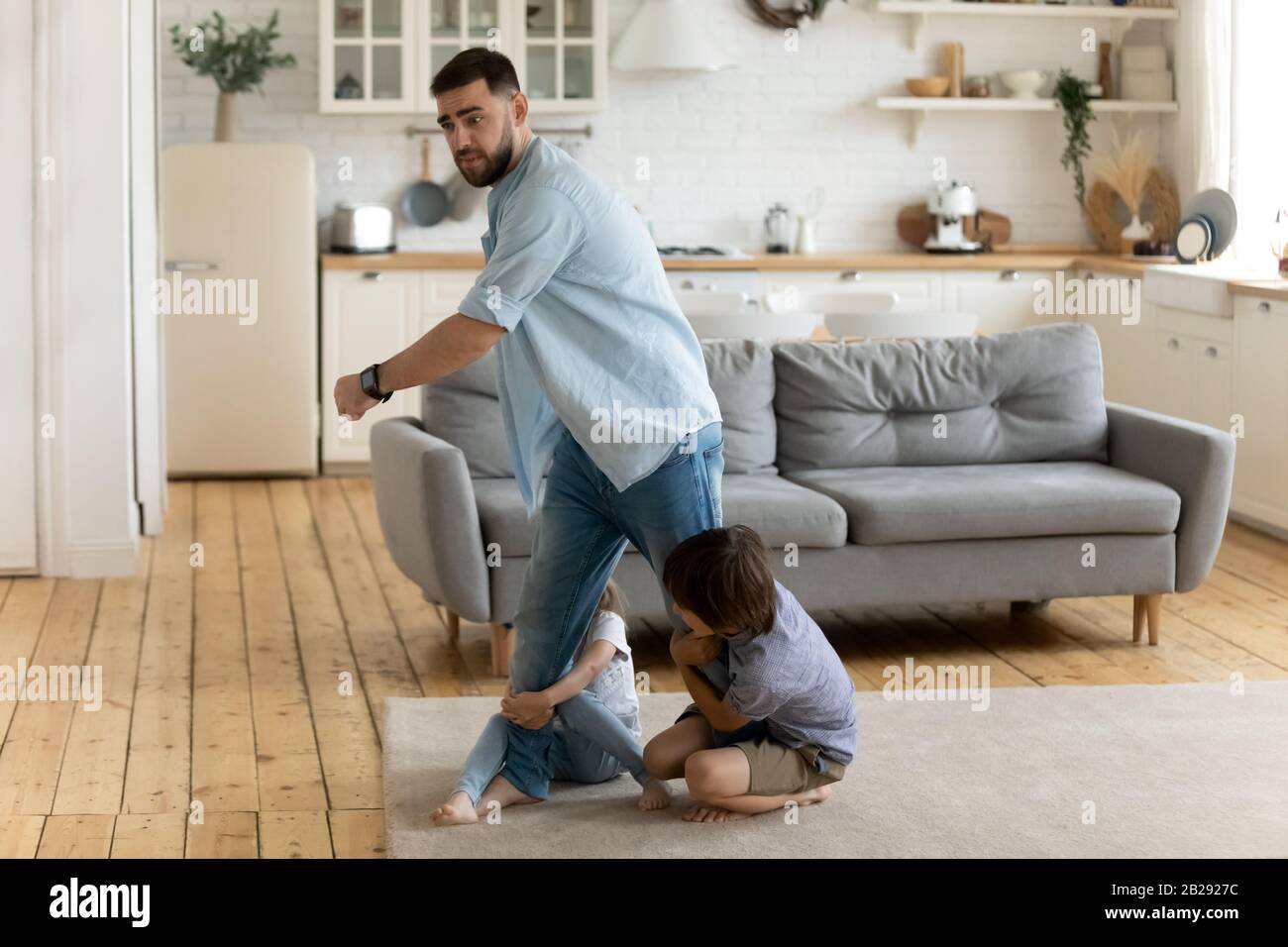 Two little children not let father go Stock Photo