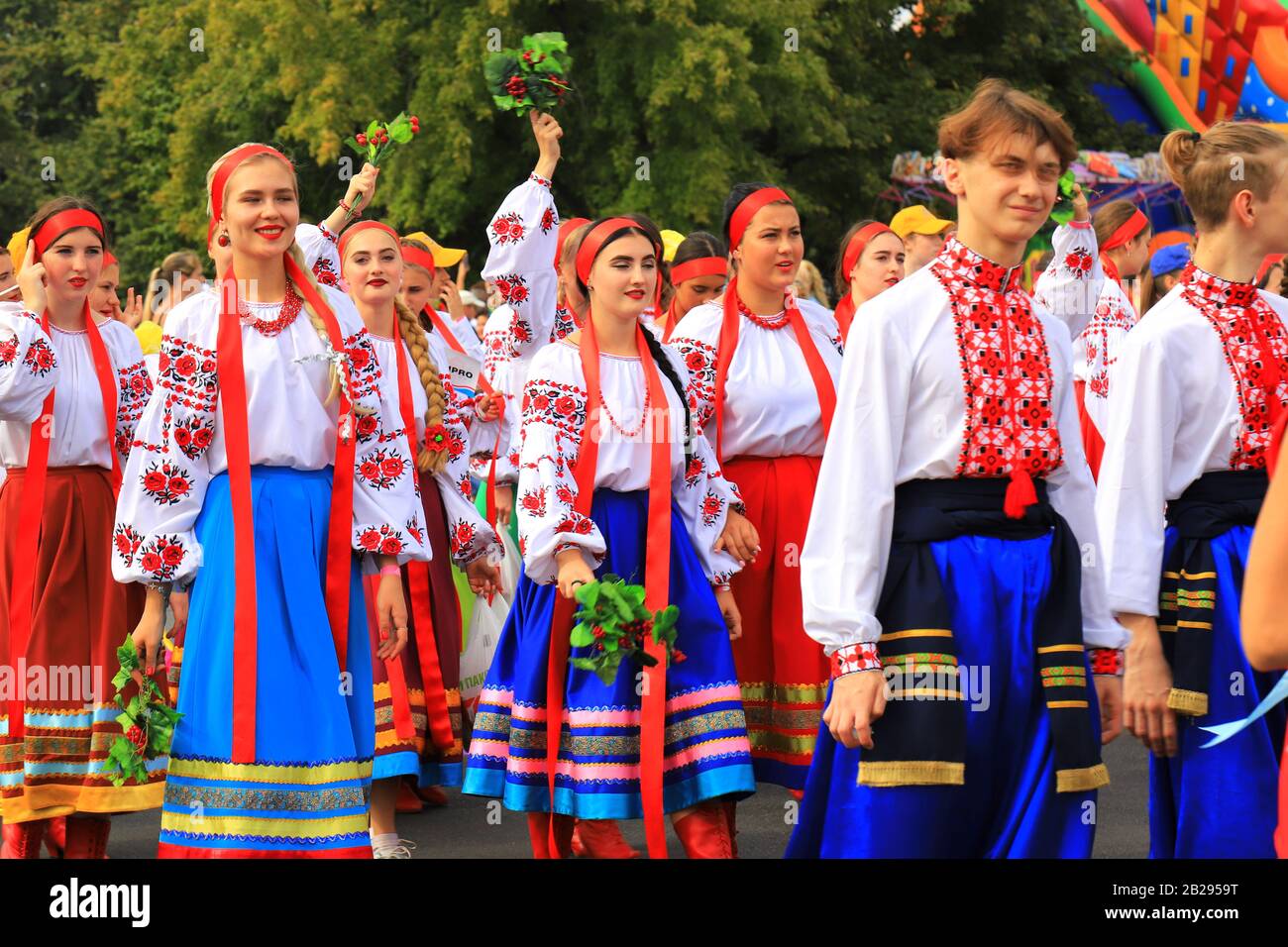 Young women and men in national Ukrainian costumes and embroidered shirts go at the festival. Holiday City Day in Dnipro, Dnepropetrovsk, Ukraine Stock Photo
