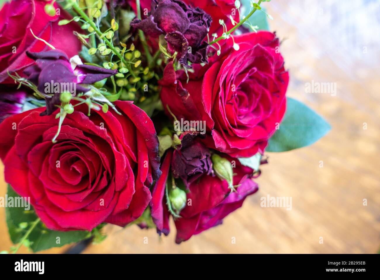 A small vase of red roses and other flowers form a decorative centrepiece Stock Photo Alamy