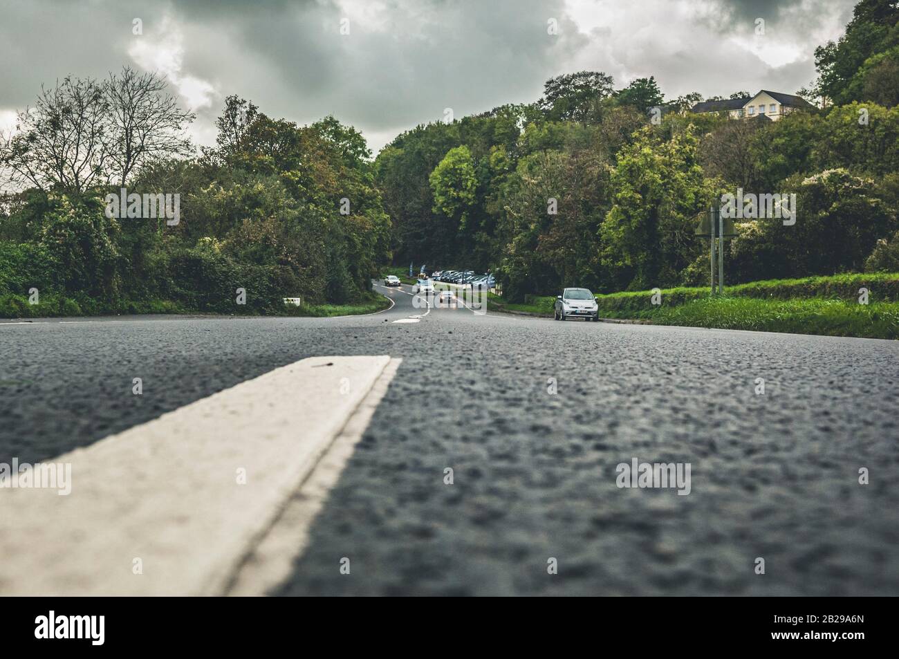 Low view of country road, with broken white lines, disappearing into the distance Stock Photo
