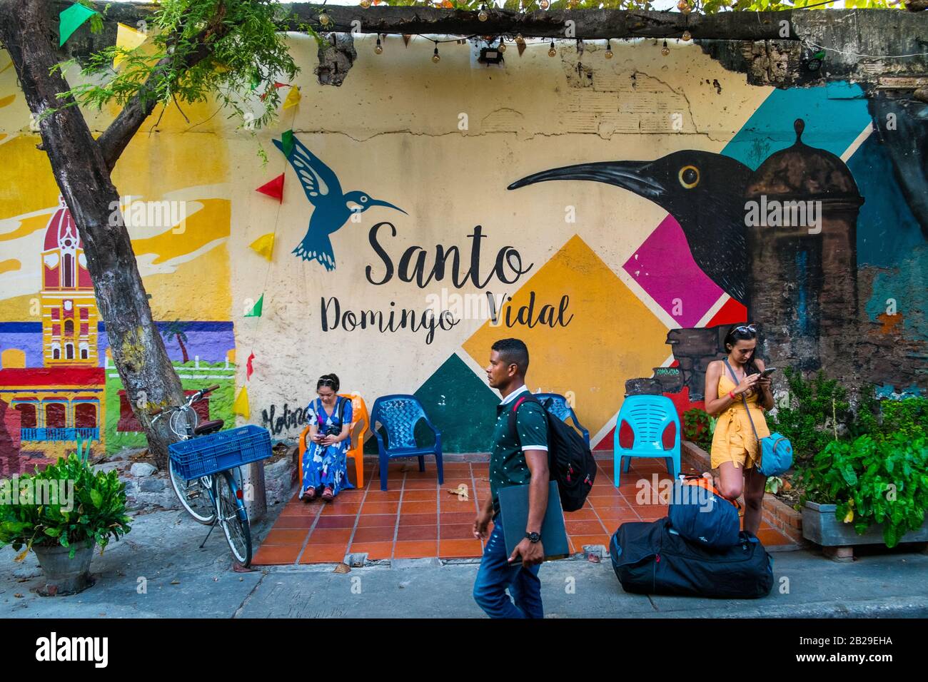 A female tourist stands by a colorful wall in the Getsamaní district, Cartagena, Colombia Stock Photo