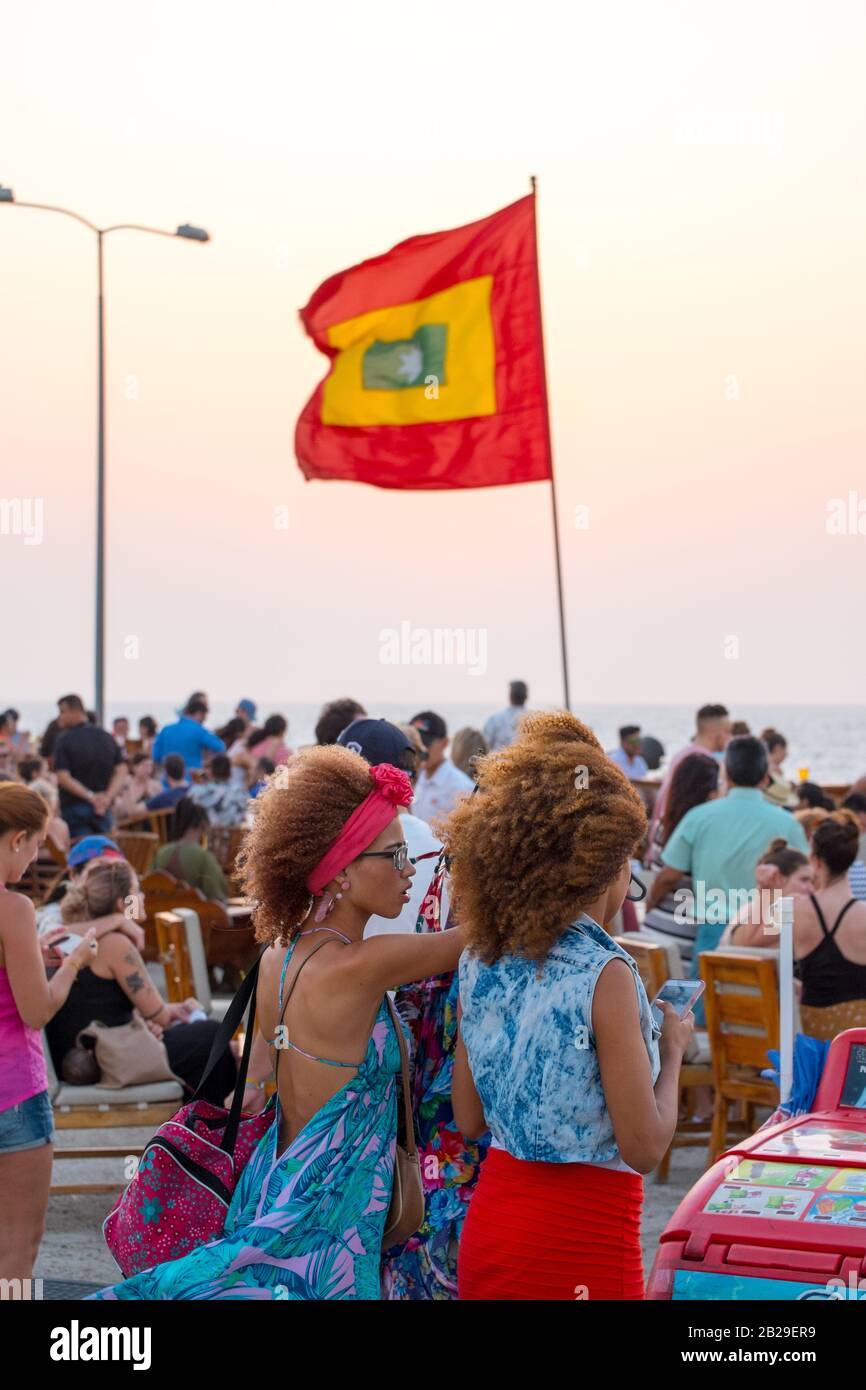 Two women and a crowd at the Café del Mar, Cartagena, Colombia Stock Photo