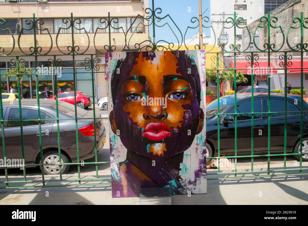 Painting of a woman with puckered lips hanging on a gate in Cartagena, Colombia Stock Photo