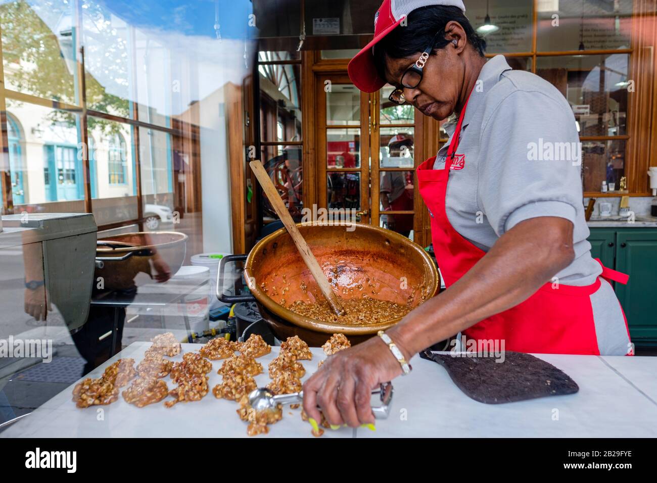 Woman cooking, working making pralines at Evans Creole Candy Factory on Decatur Street, New Orleans French Quarter New Orleans, Louisiana, USA Stock Photo