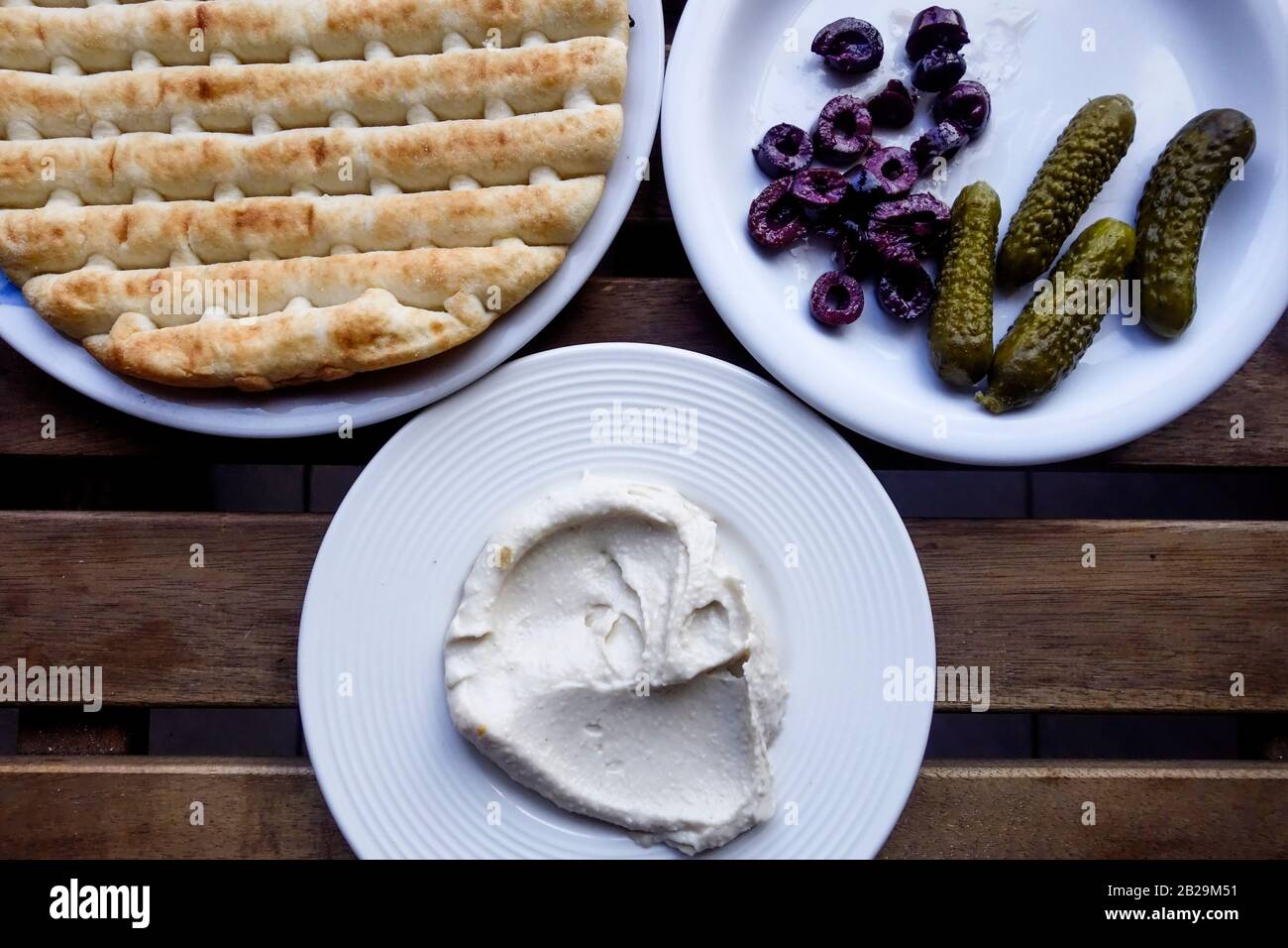 3 Plate Meze of Pita Bread, Hummus, Gherkins and Kalamon Sliced Olives, Crete, Greece Stock Photo