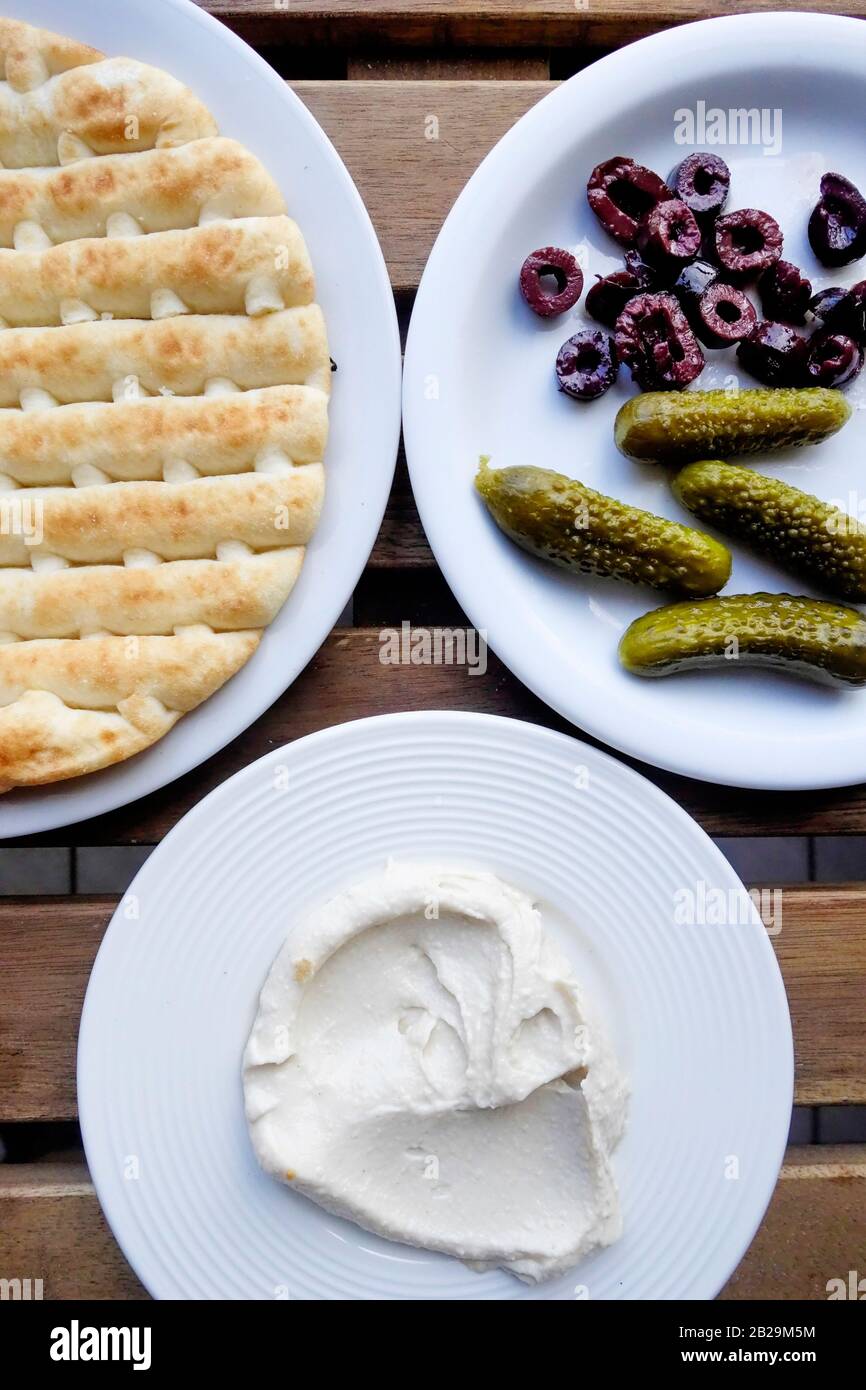 3 Plate Meze of Pita Bread, Hummus, Gherkins and Kalamon Sliced Olives, Crete, Greece Stock Photo