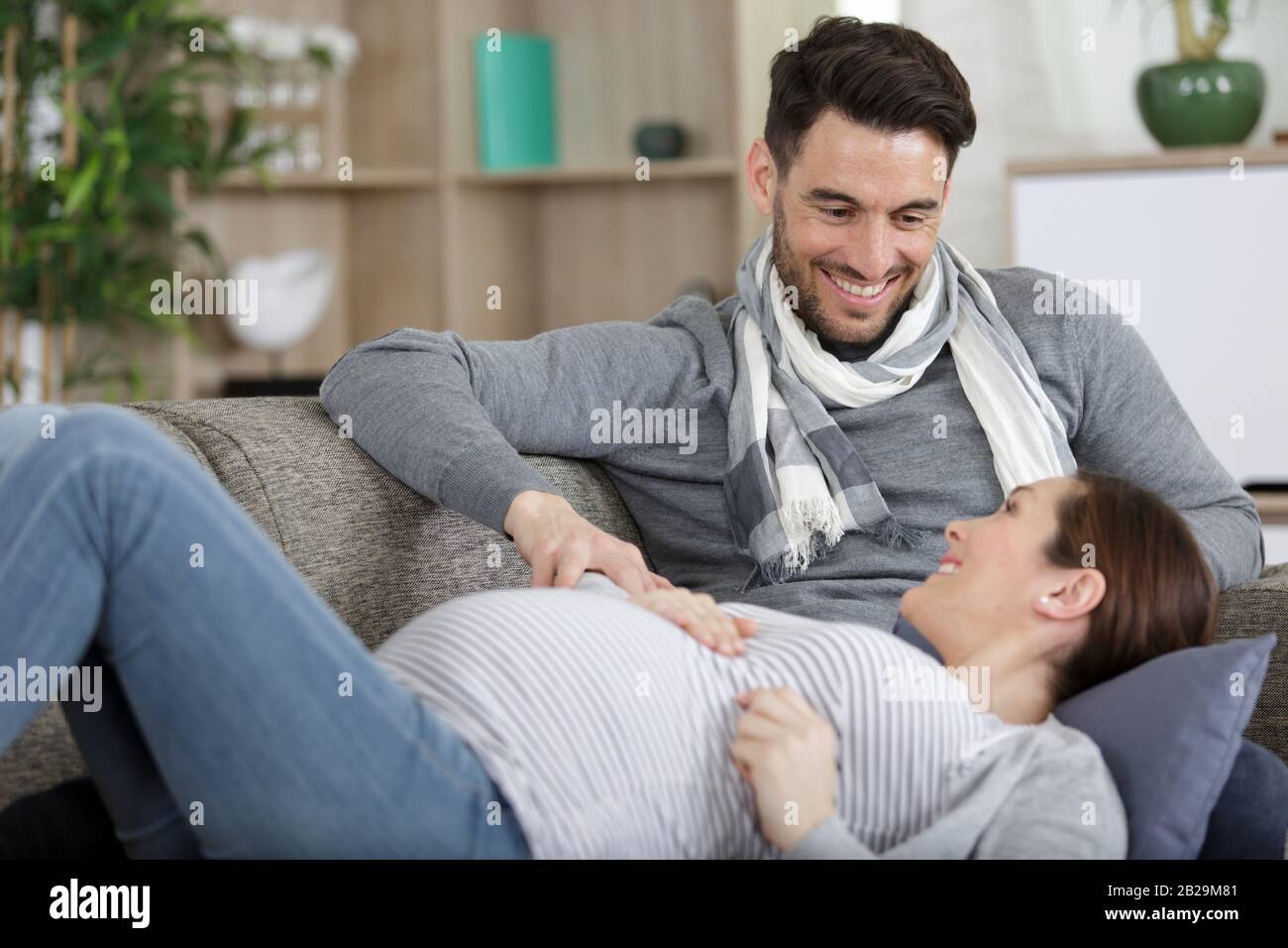 happy man and pregnant woman in living room Stock Photo - Alamy