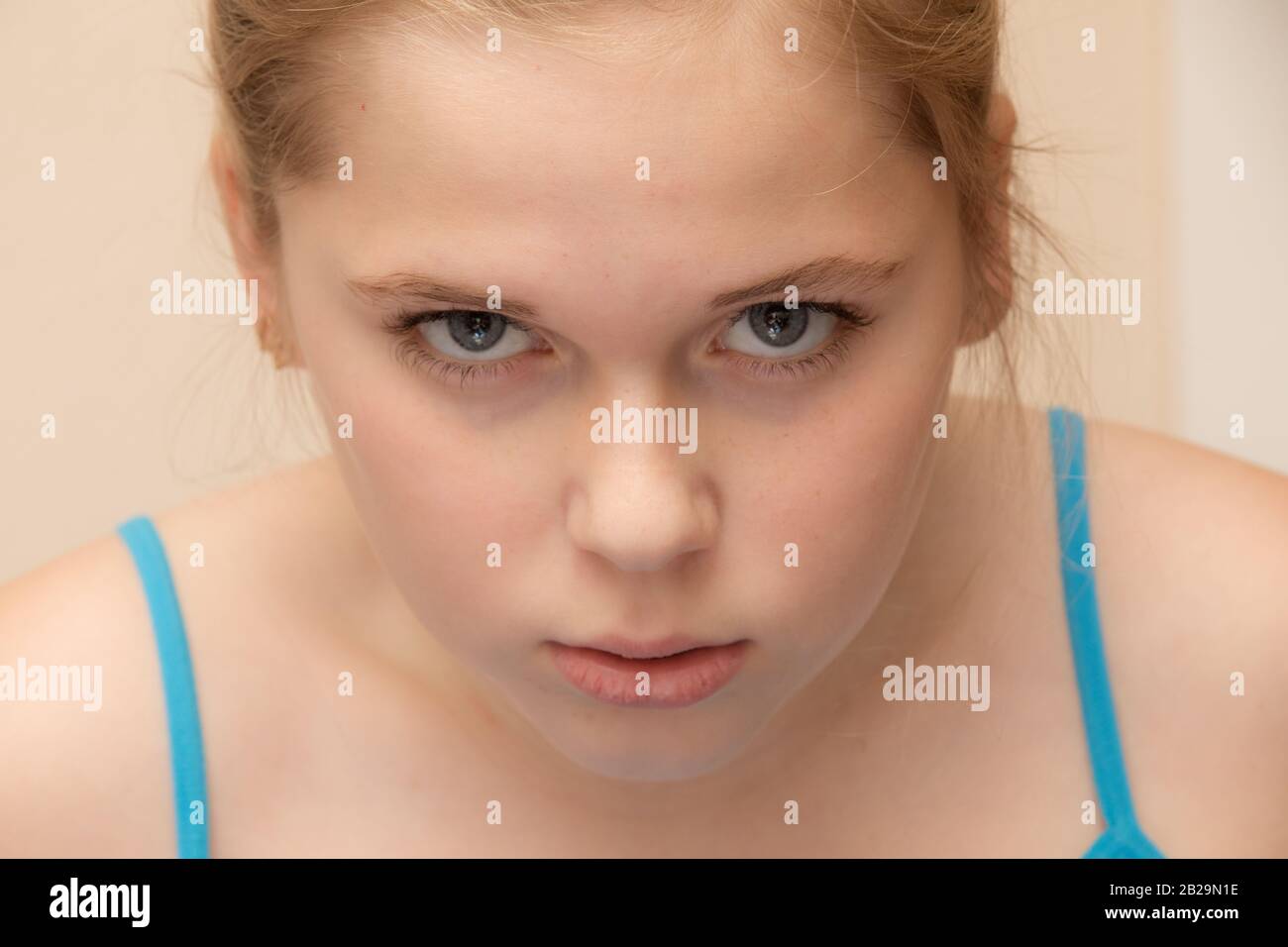 angry preteen with her head hanging down Stock Photo