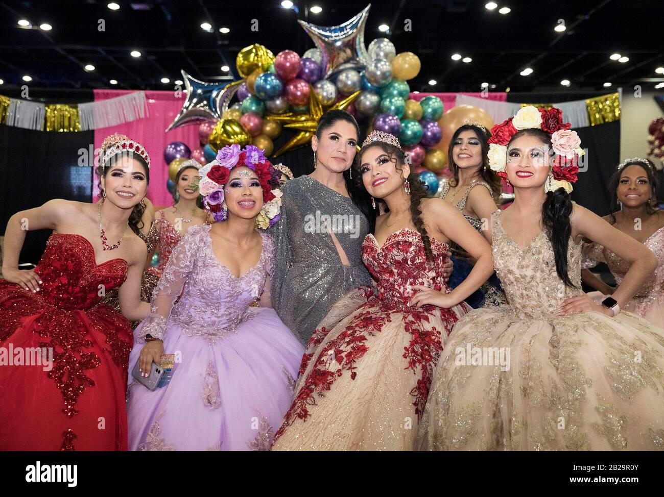 Houston, USA. 1st Mar, 2020. A Houston-based Quinceanera dress designer takes a photograph with her models at the Big One Quinceanera Expo in Houston, Texas, United States, on March 1, 2020. Quinceanera is a tradition in Latin America marking the transition of girls from childhood to adulthood. Credit: Yi-Chin Lee/Xinhua/Alamy Live News Stock Photo