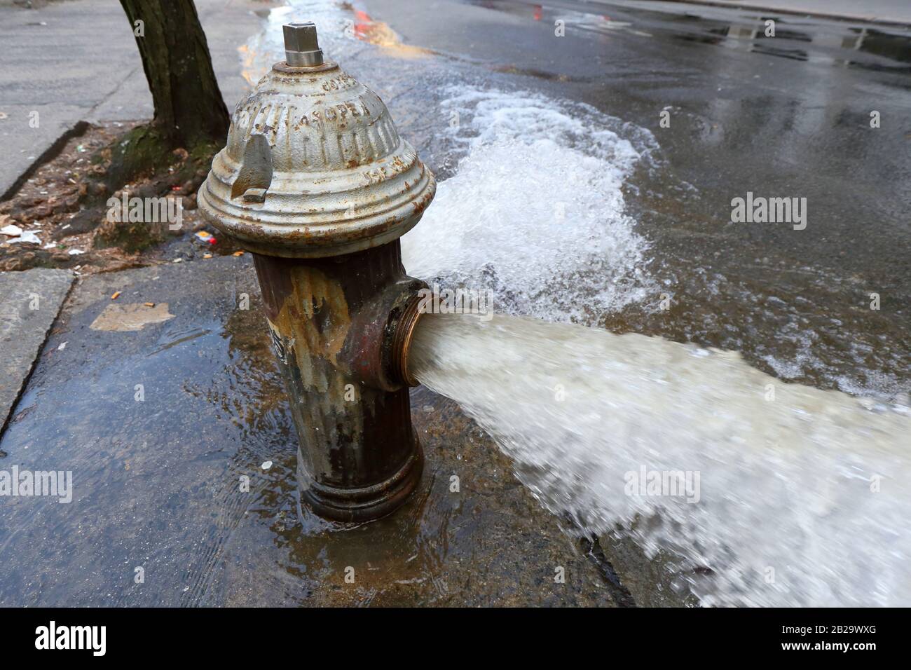 An open fire hydrant in New York. Workers of a nearby water main repair