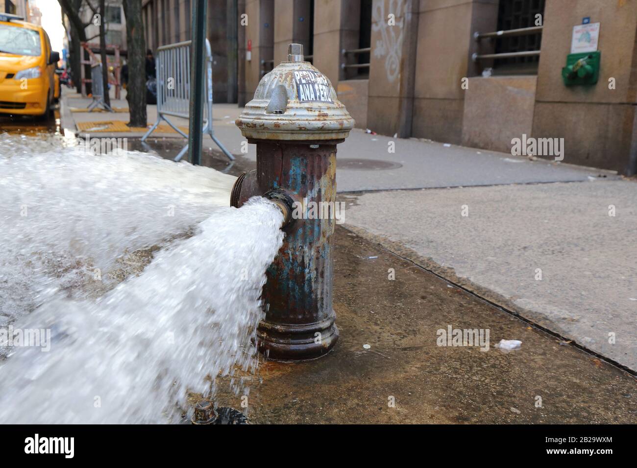 An open fire hydrant in New York. Workers of a nearby water main repair