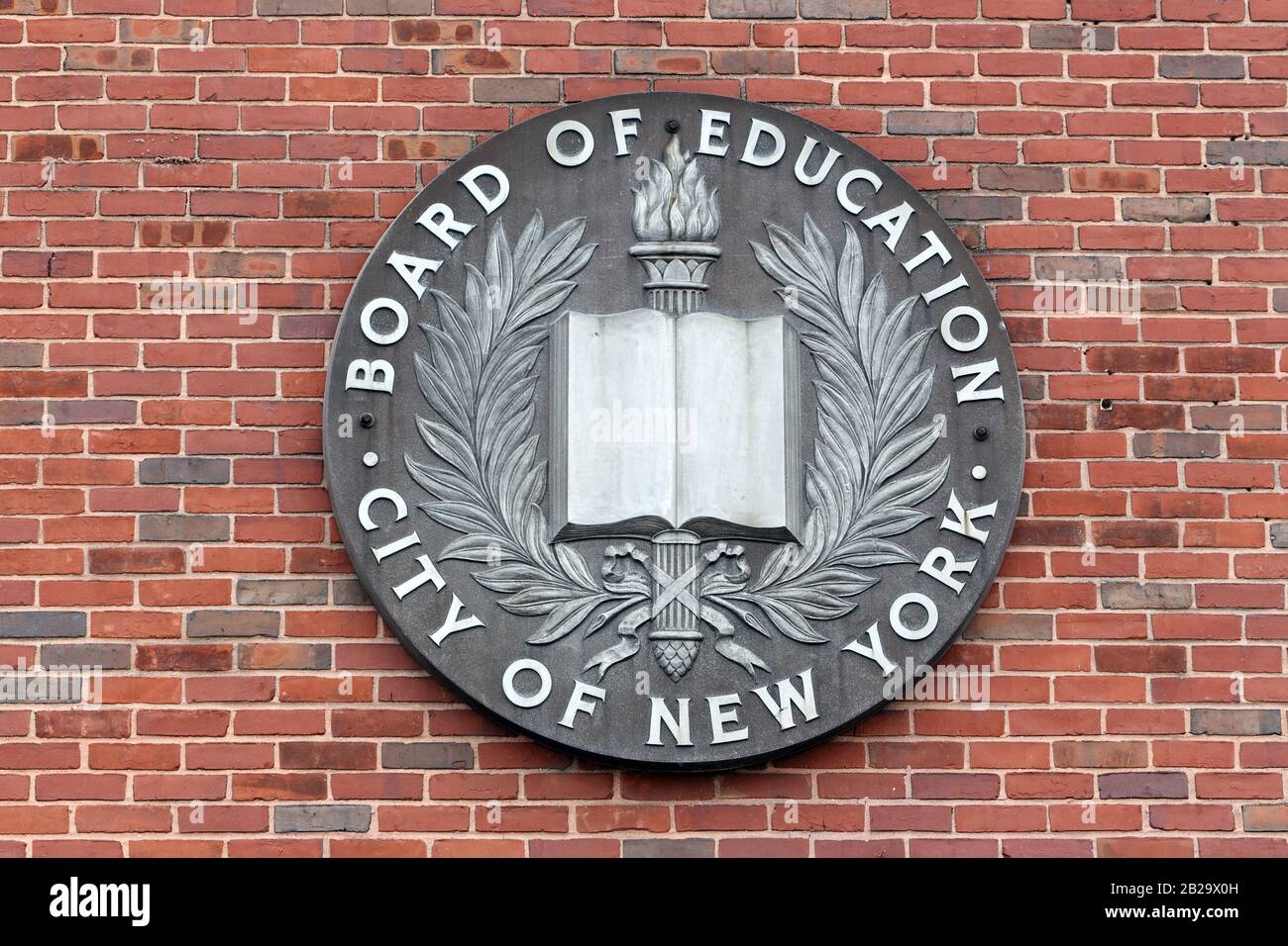 The seal of the old NYC Board of Education on a brick wall in New York