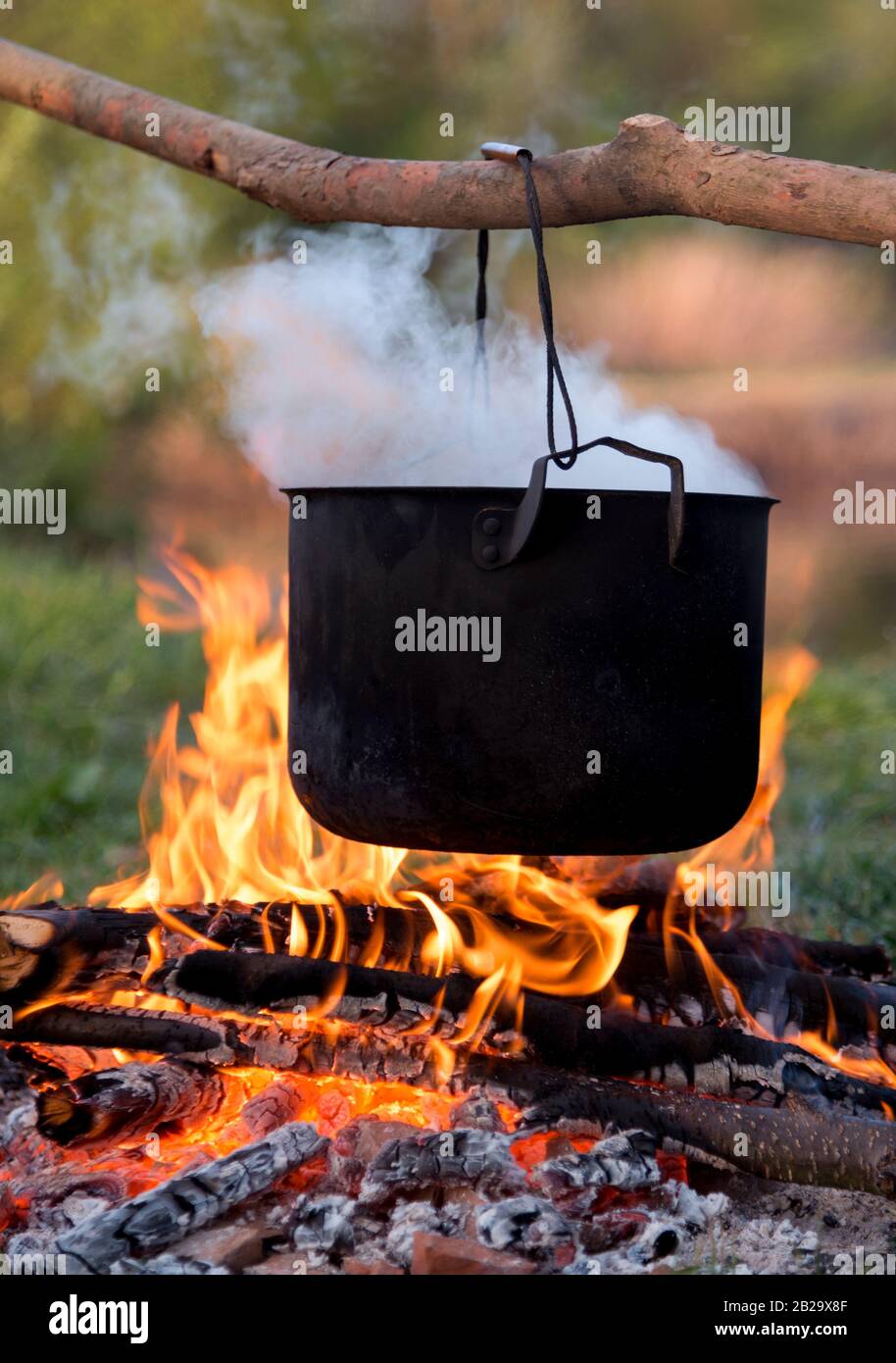 https://c8.alamy.com/comp/2B29X8F/black-pot-are-heating-under-fire-scene-from-travel-2B29X8F.jpg