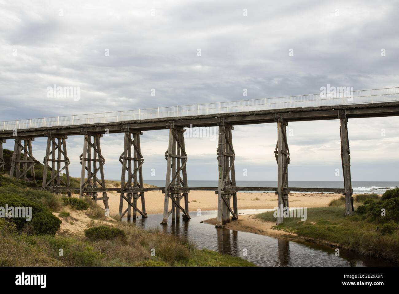 Gipplsand, Kilcunda Bourne Creek Trestle bridge on an overcast day with ocean in background Stock Photo