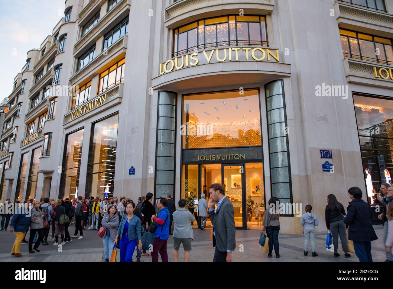 People in front of Louis Vuitton Maison Champs Élysées in Paris, France Stock Photo