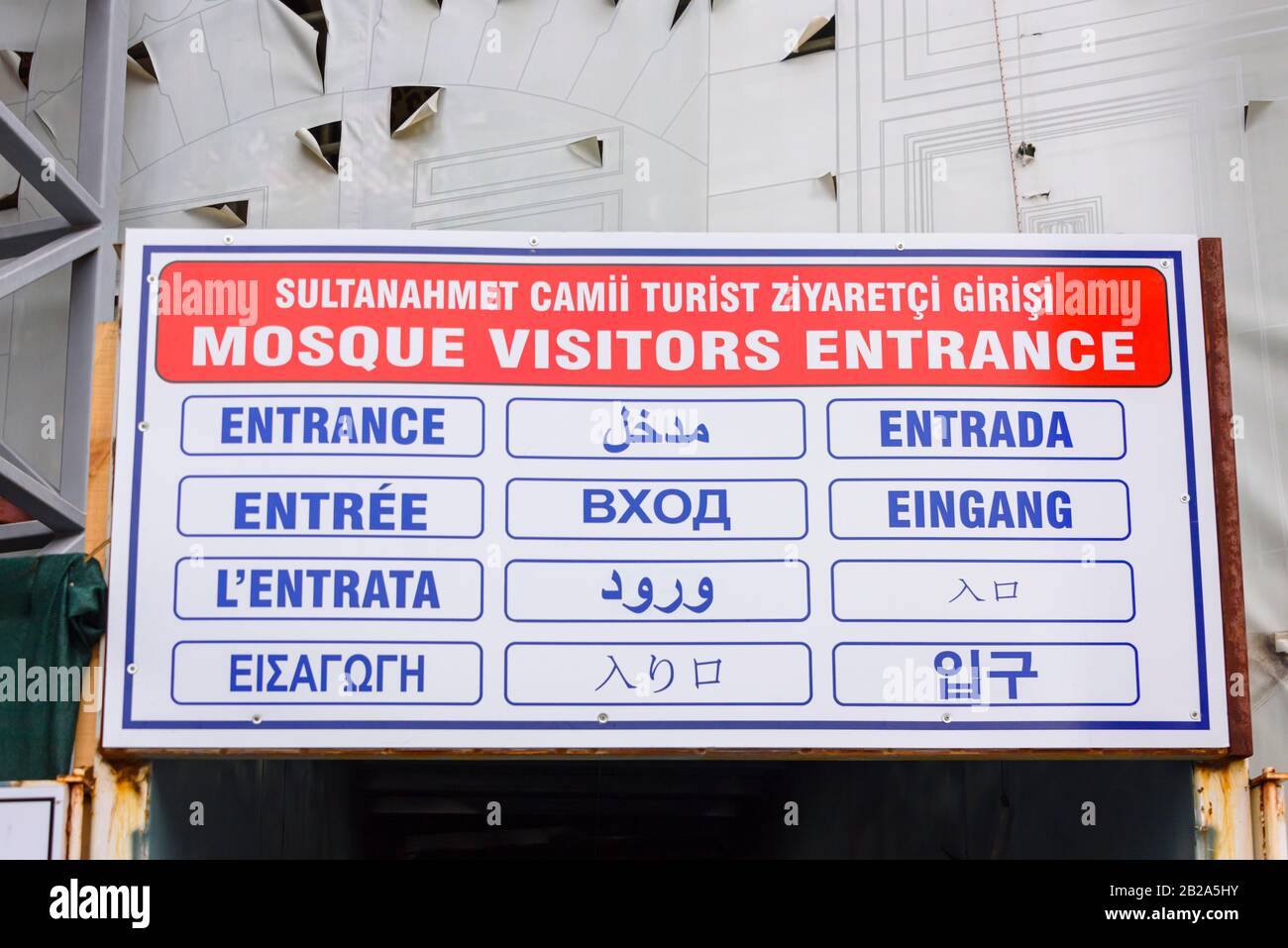 Multi-lingual sign for tourists indicating the visitors' entrance of the Blue Mosque, Istanbul, Turkey.  Visitors are not permitted to use the main en Stock Photo