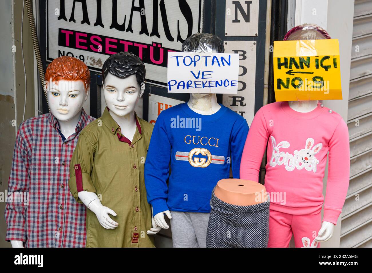 Mannequins wearing childrens clothing outside a clothes shop in Istanbul, Turkey.  One is wearing a fake Gucci tee-shirt. Stock Photo