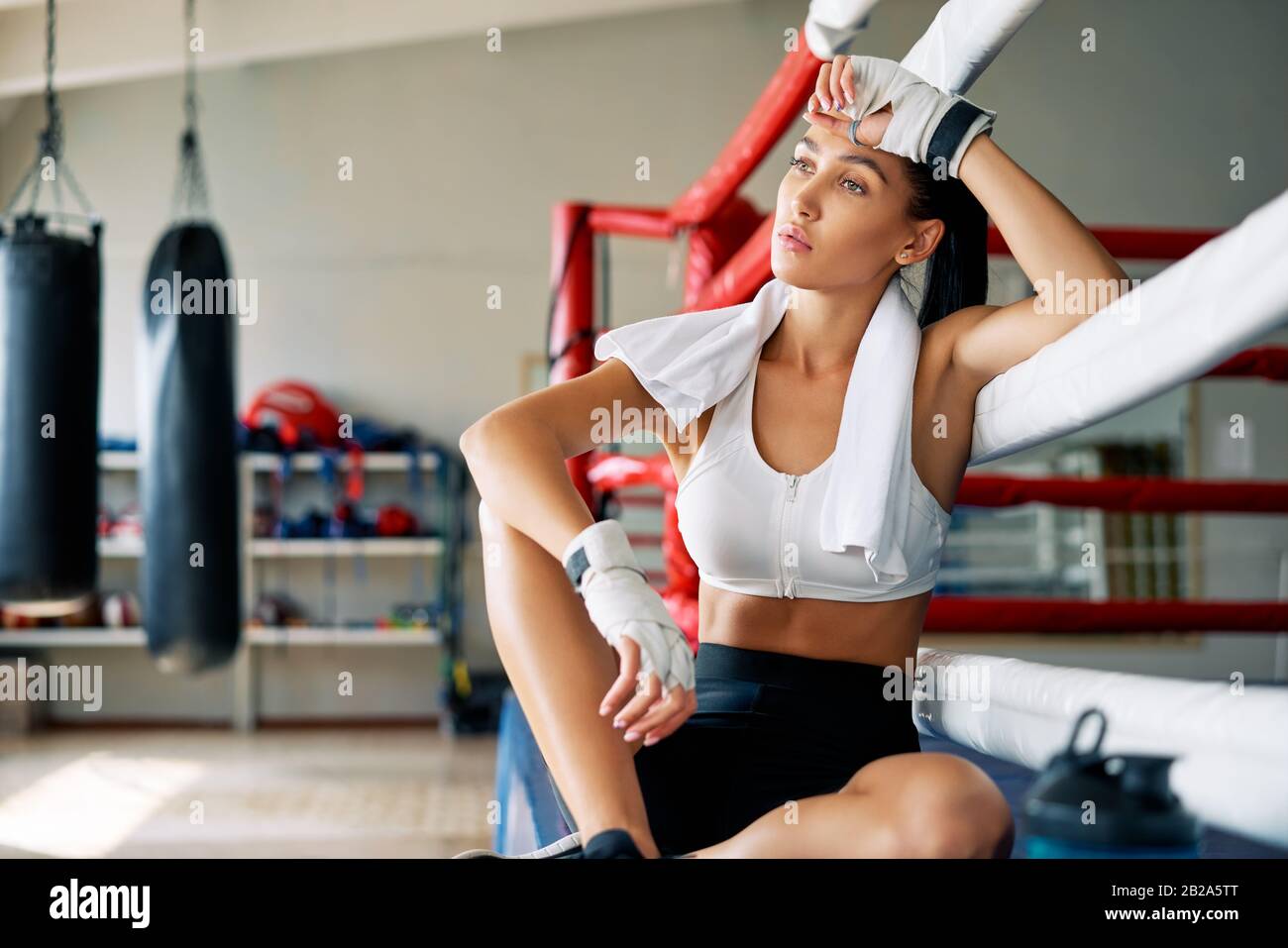 Young beautiful woman relax after fight or workout exercising in boxing ...