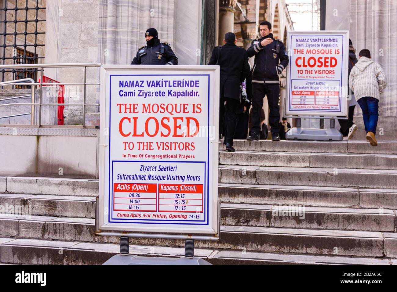 Police stand behind a sign outside the Blue Mosque saying that the mosque is closed to visitors during prayer. Istanbul, Turkey Stock Photo