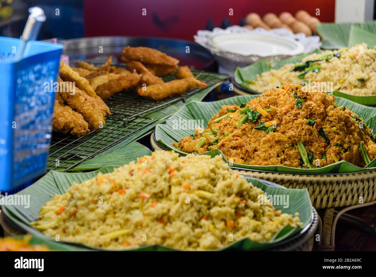 Plates of fried rice on banana leaves in the kitchen of a street food restaurant, Bangkok