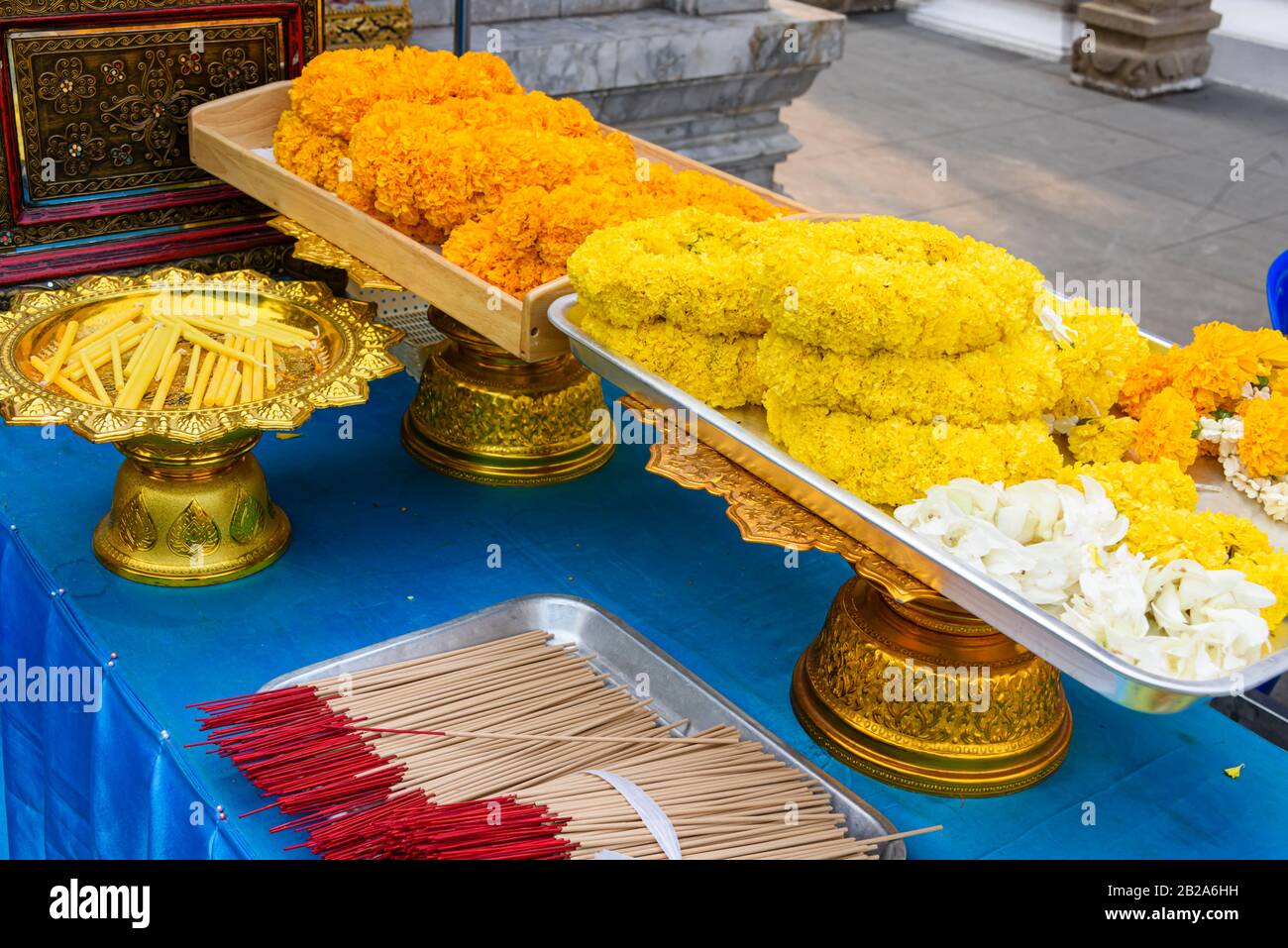 Garlands of orange and yellow chrysanthemum flowers with incense at a Buddhist temple, Bangkok, Thailand Stock Photo